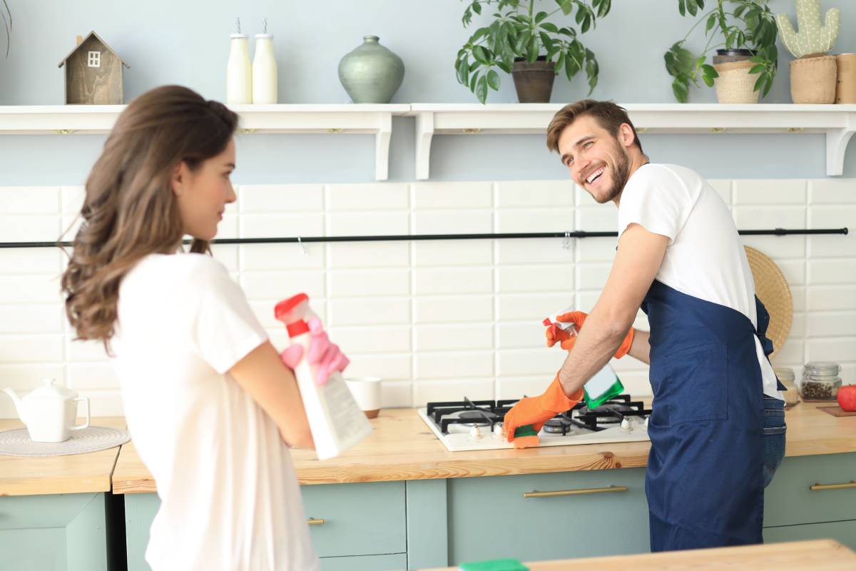 Coppia che pulisce la cucina