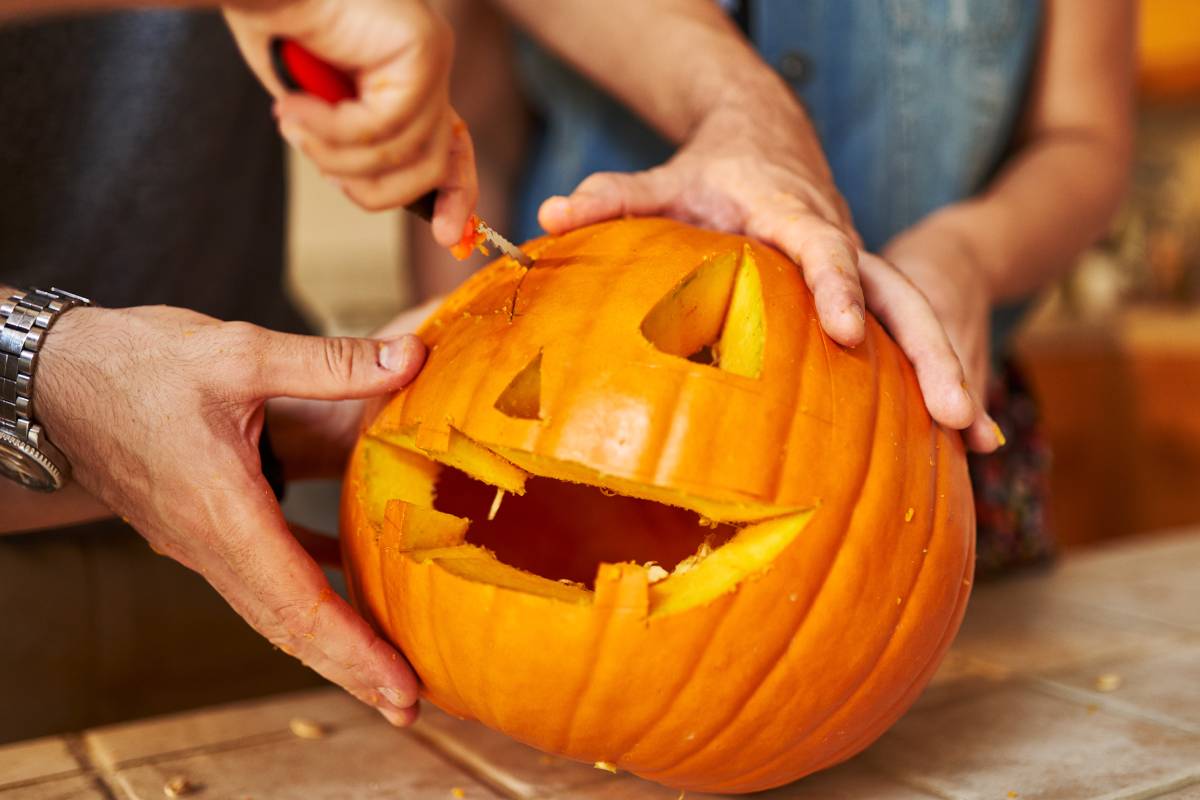 Mani che intagliano la zucca
