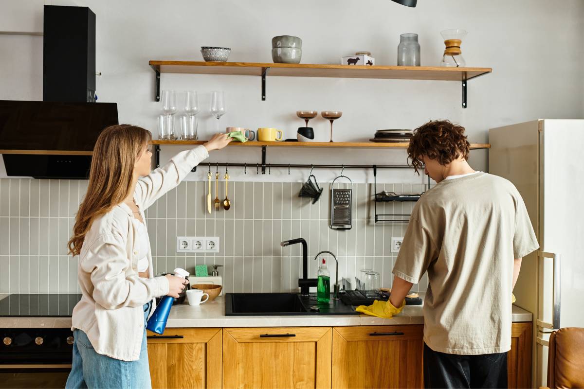 Coppia che pulisce la cucina