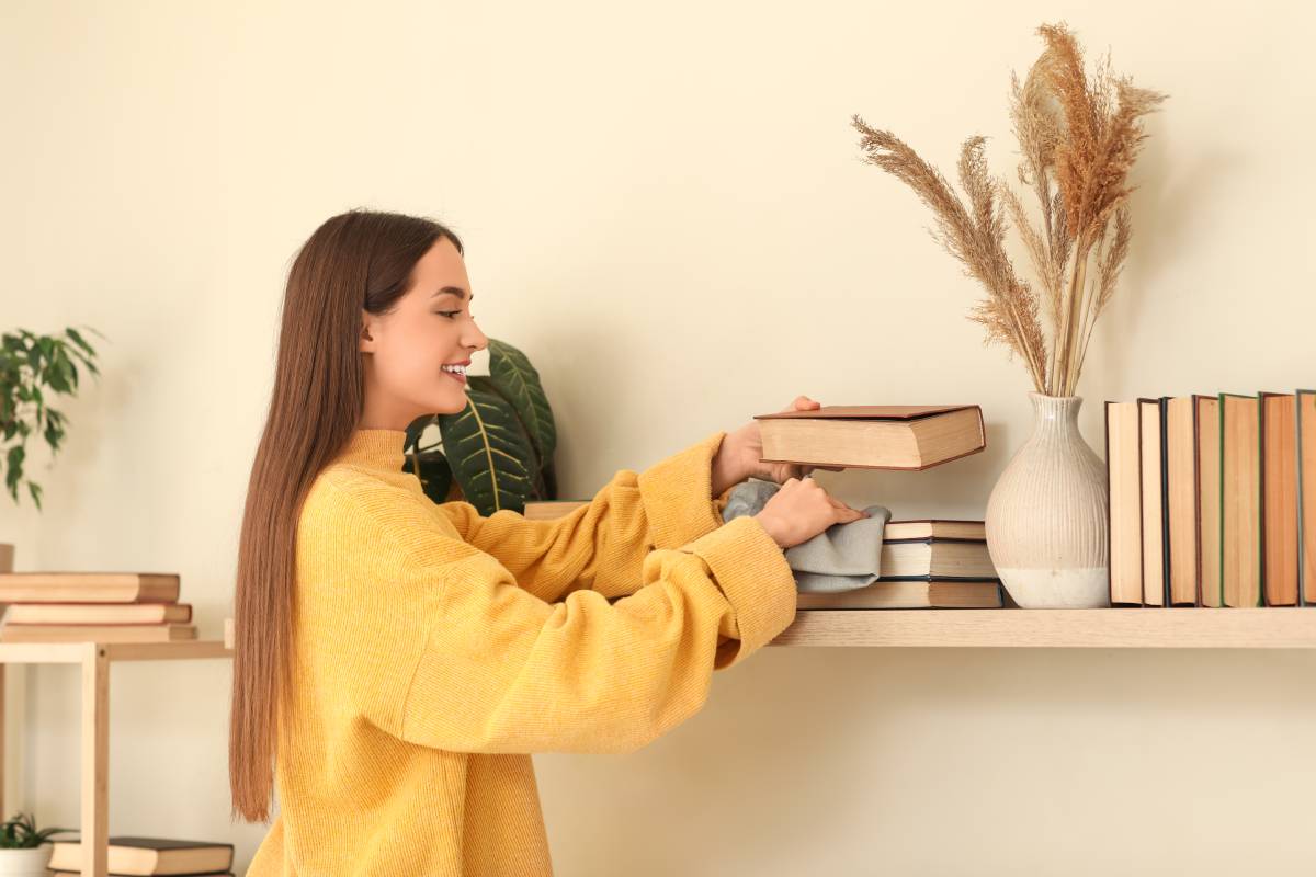 Donna che spolvera i libri