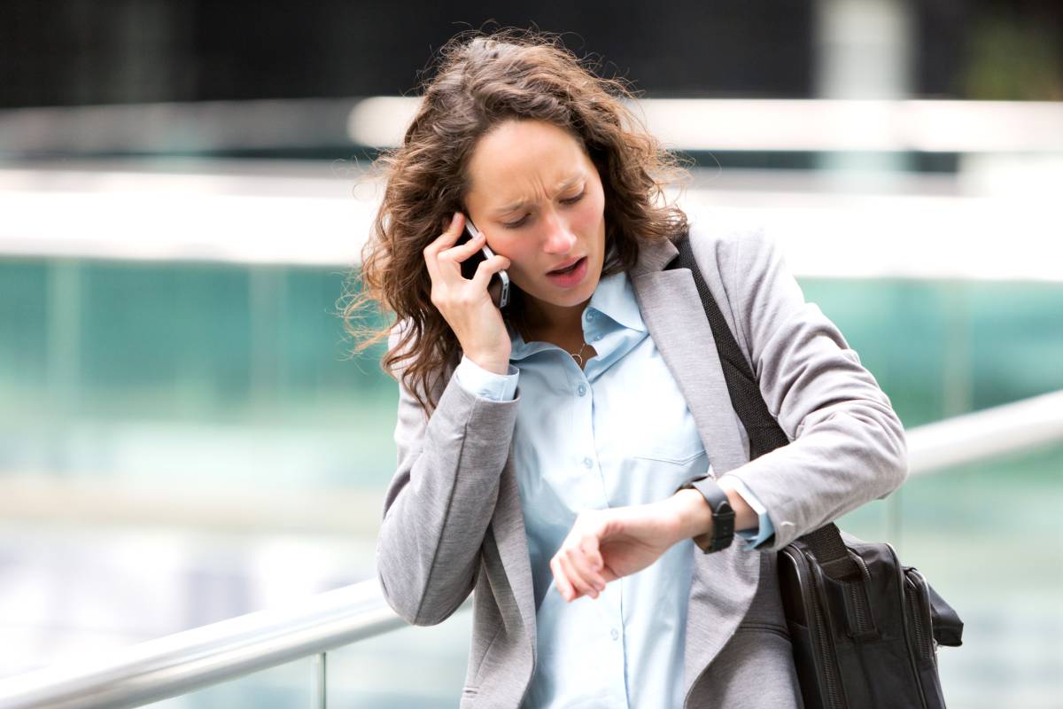 donna in ritardo che guarda l'orologio